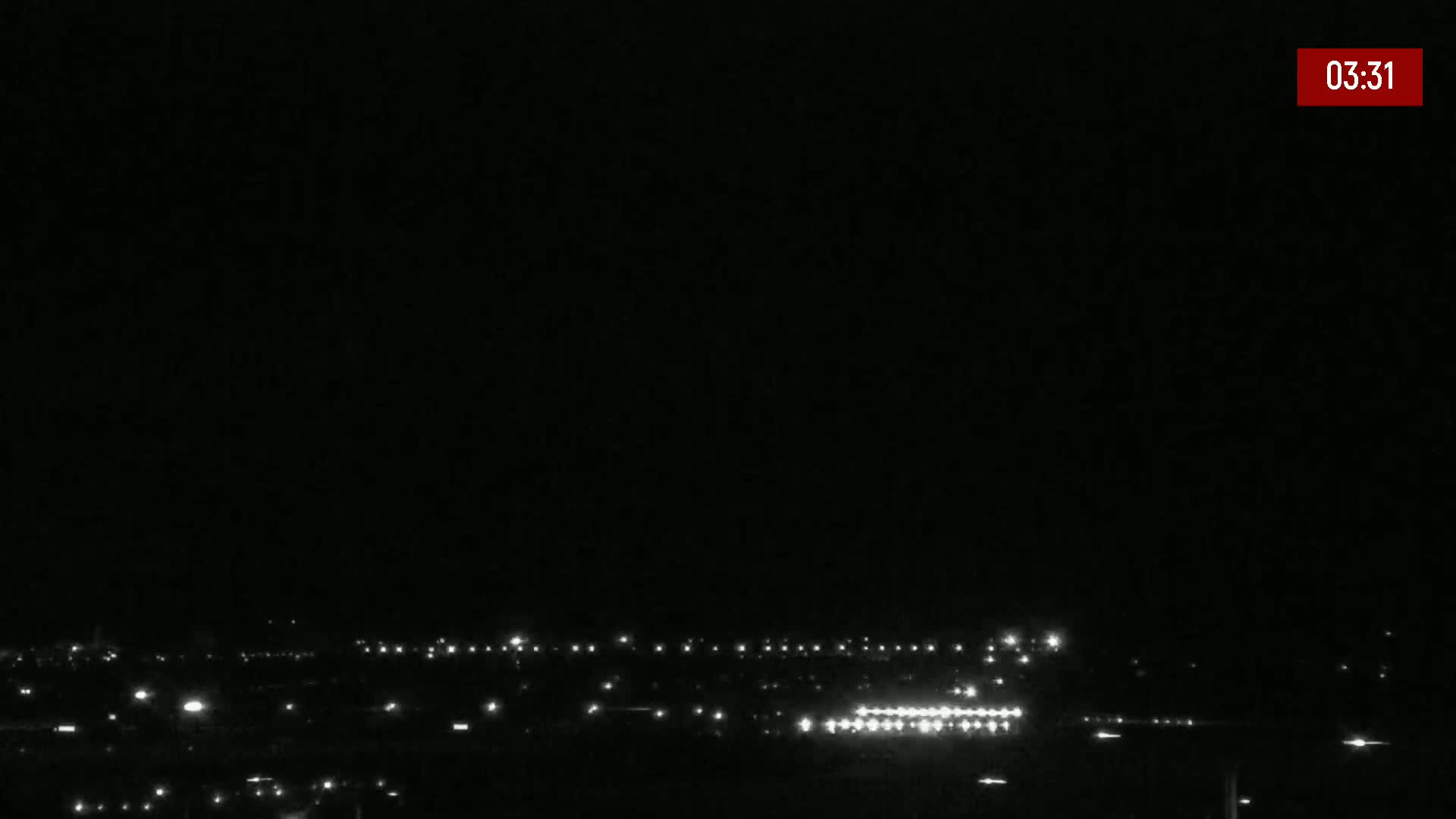 A mostly cloudy sky hangs over an airport runway where construction equipment is visible and a Ryanair Boeing 737 is preparing for departure.