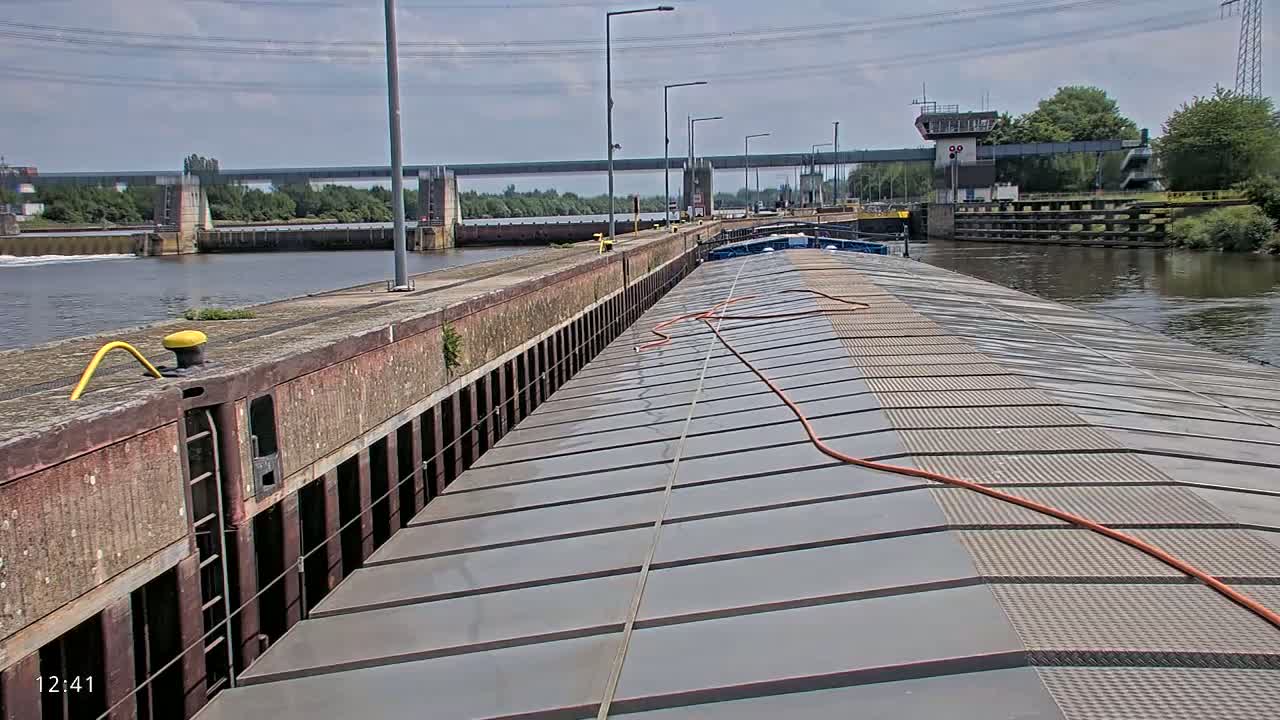 A barge travels through a lock on a sunny day.