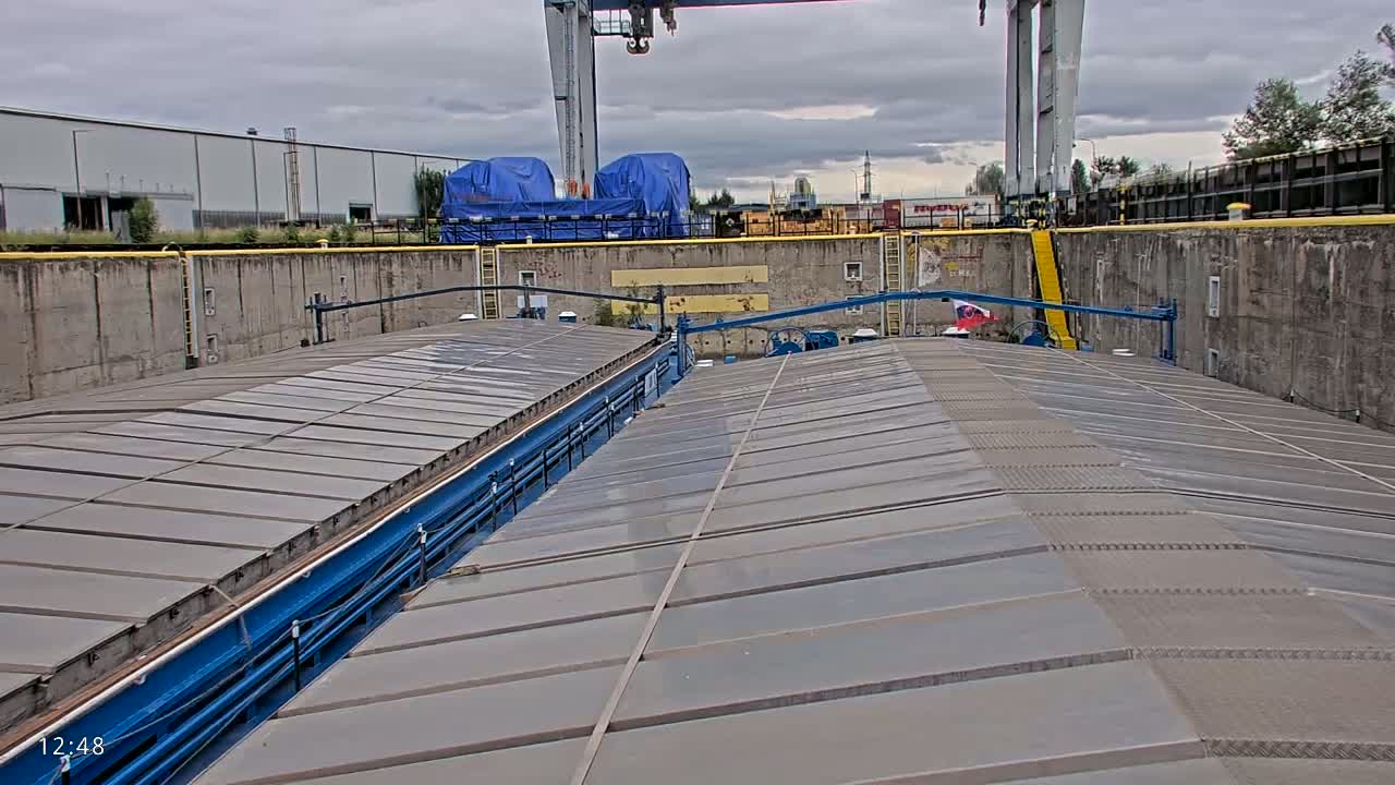 A view from atop a barge in a lock, under an overcast sky.