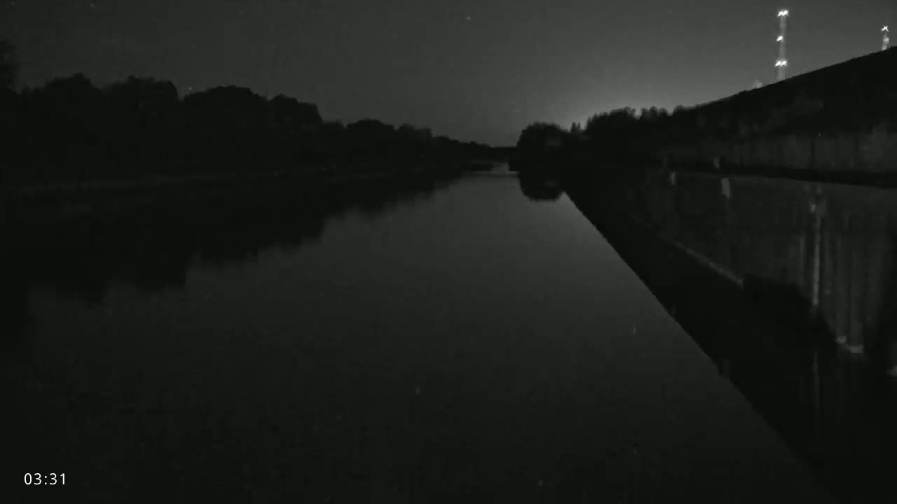 A blue barge is traveling through a lock on an overcast day.