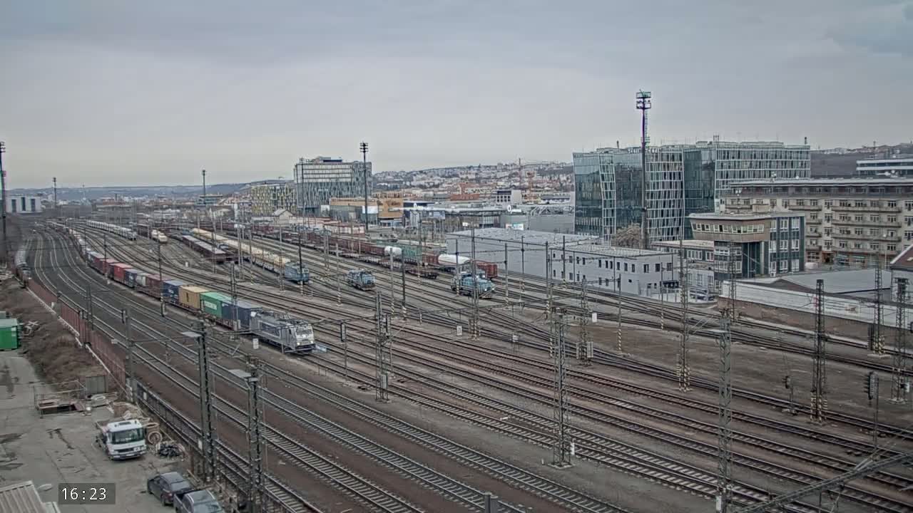 A large railway yard with numerous freight trains and tracks under an overcast sky.