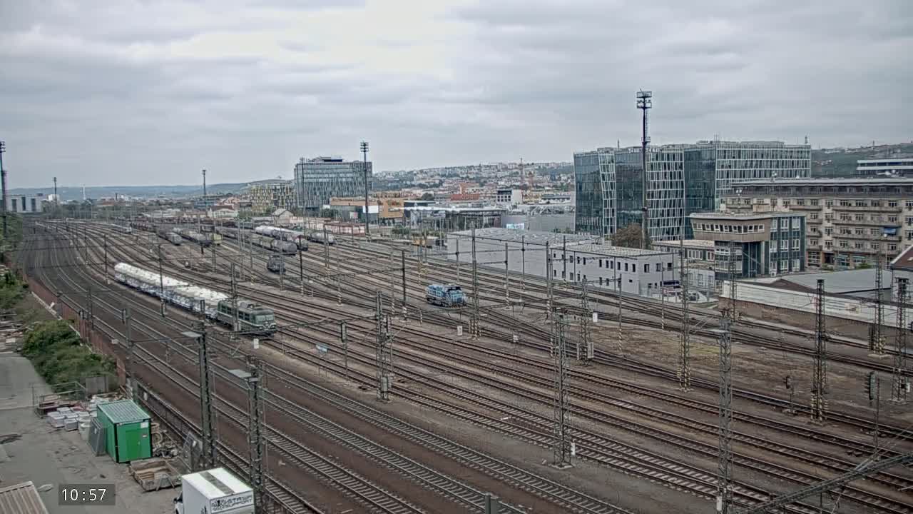 A large railway yard with numerous trains and tracks under an overcast sky.