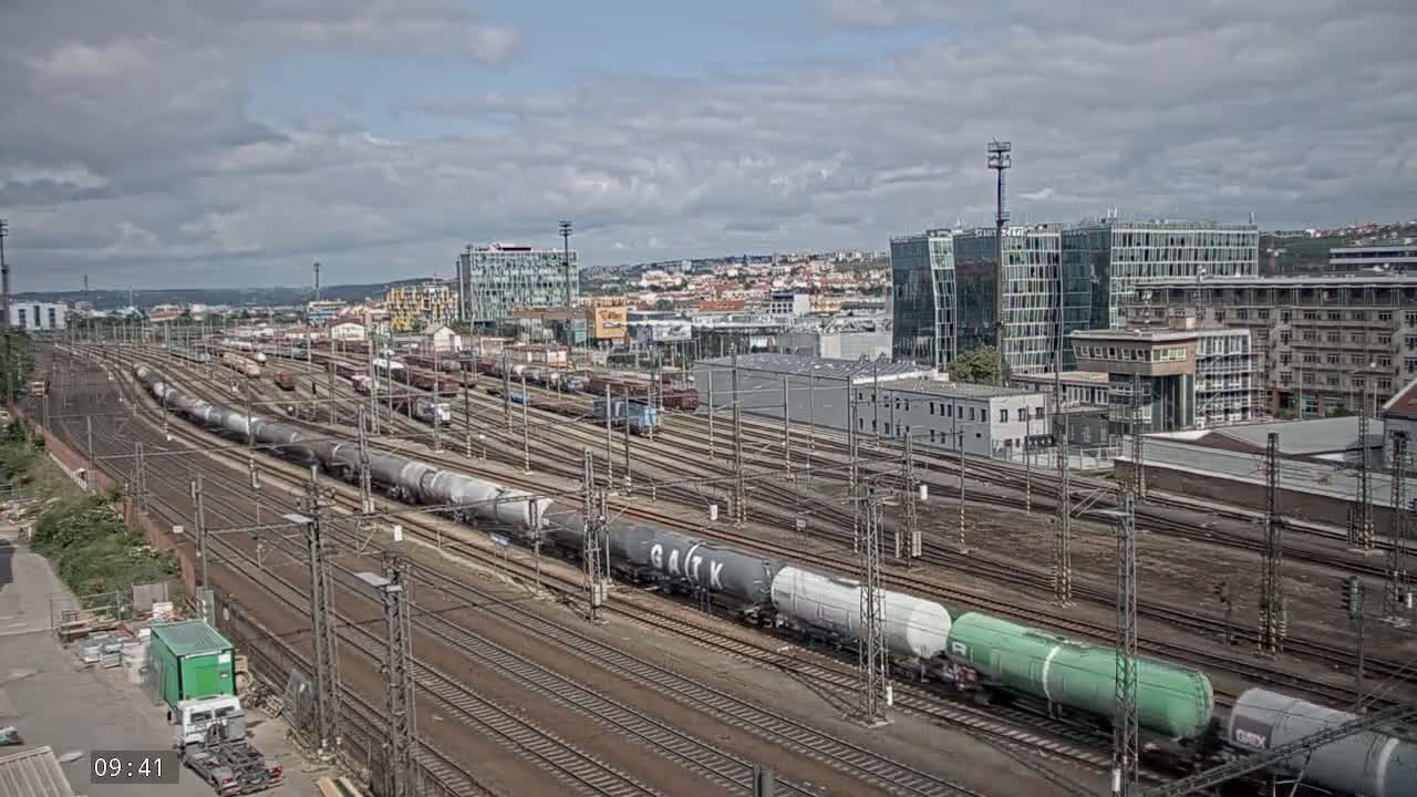 A sprawling railway yard with numerous freight trains and tracks under a partly cloudy sky.