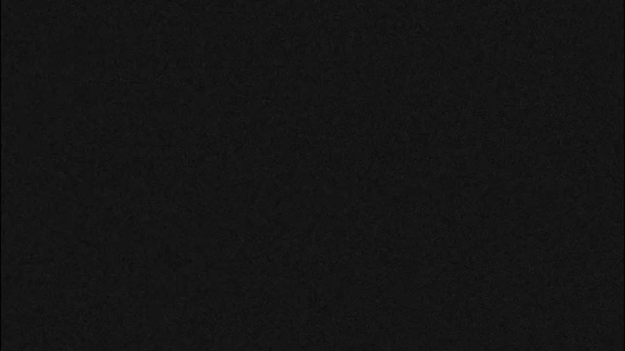 The image displays a solid black field with a subtle, uniform grainy texture.