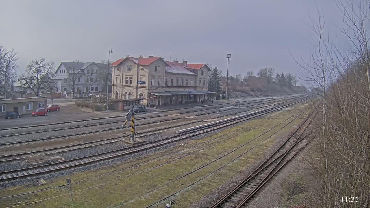 A long view of a train station with several tracks extending into the distance on an overcast day.