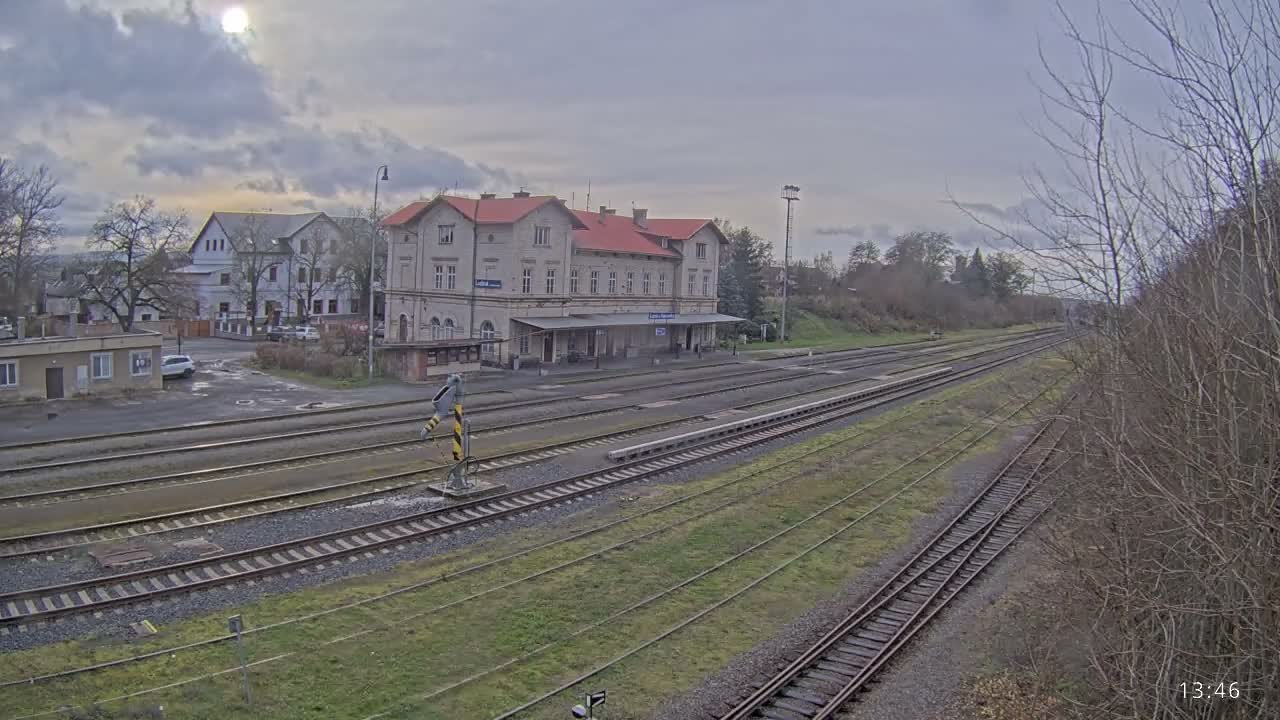 A nighttime view of a train station with multiple train tracks, illuminated by artificial lights under a dark sky.