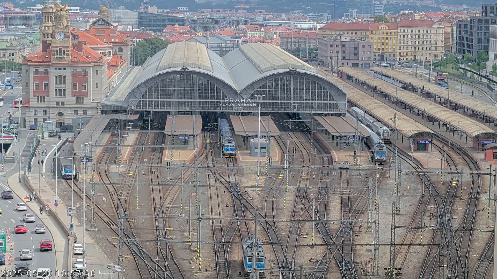 A large train station with numerous tracks and trains, viewed from above on an overcast day.