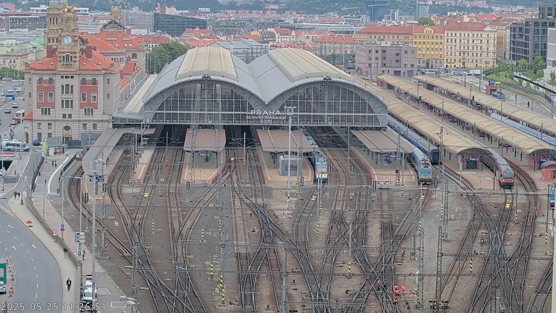 A large train station with numerous tracks and trains, viewed from above on an overcast day.