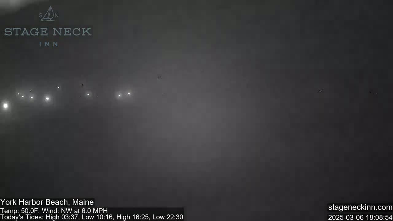 A foggy, nighttime scene shows distant lights in the far background under a dark sky.