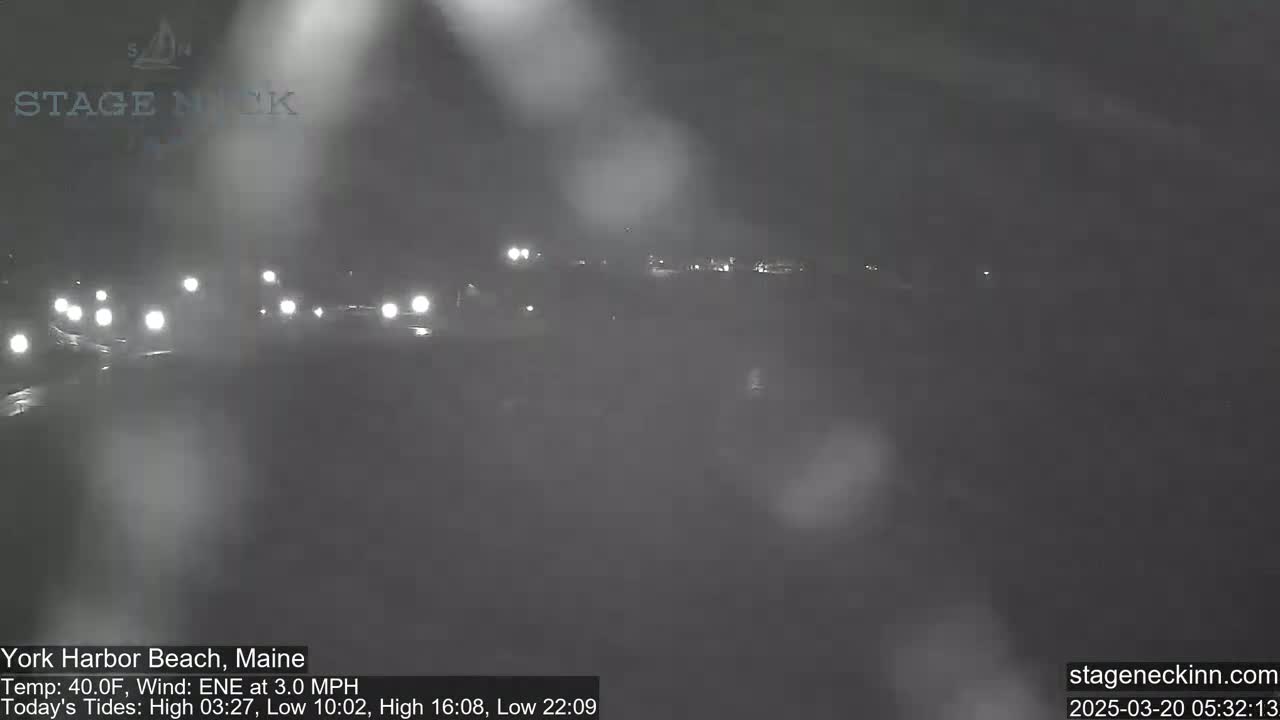 A nighttime view of a road with headlights visible in foggy conditions.