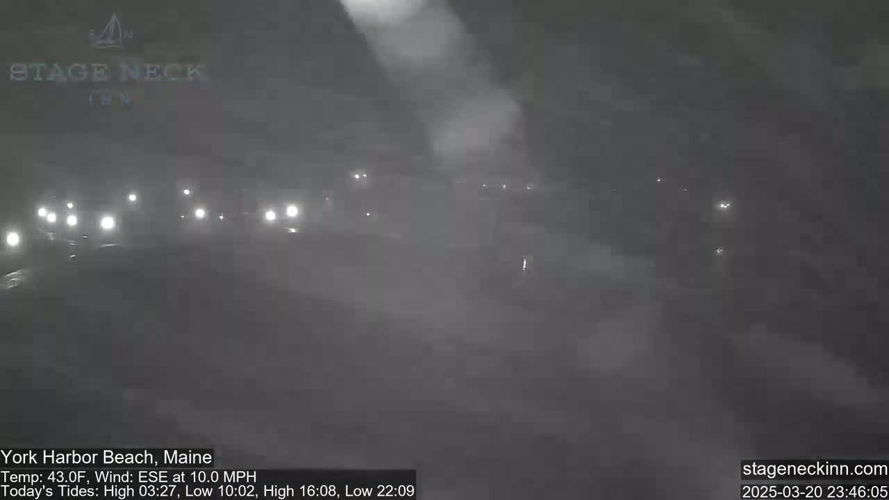 A foggy night scene shows a road with several vehicles visible through the dense fog.