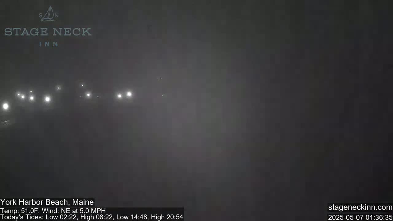 Faintly lit vehicles are visible in the fog at night.