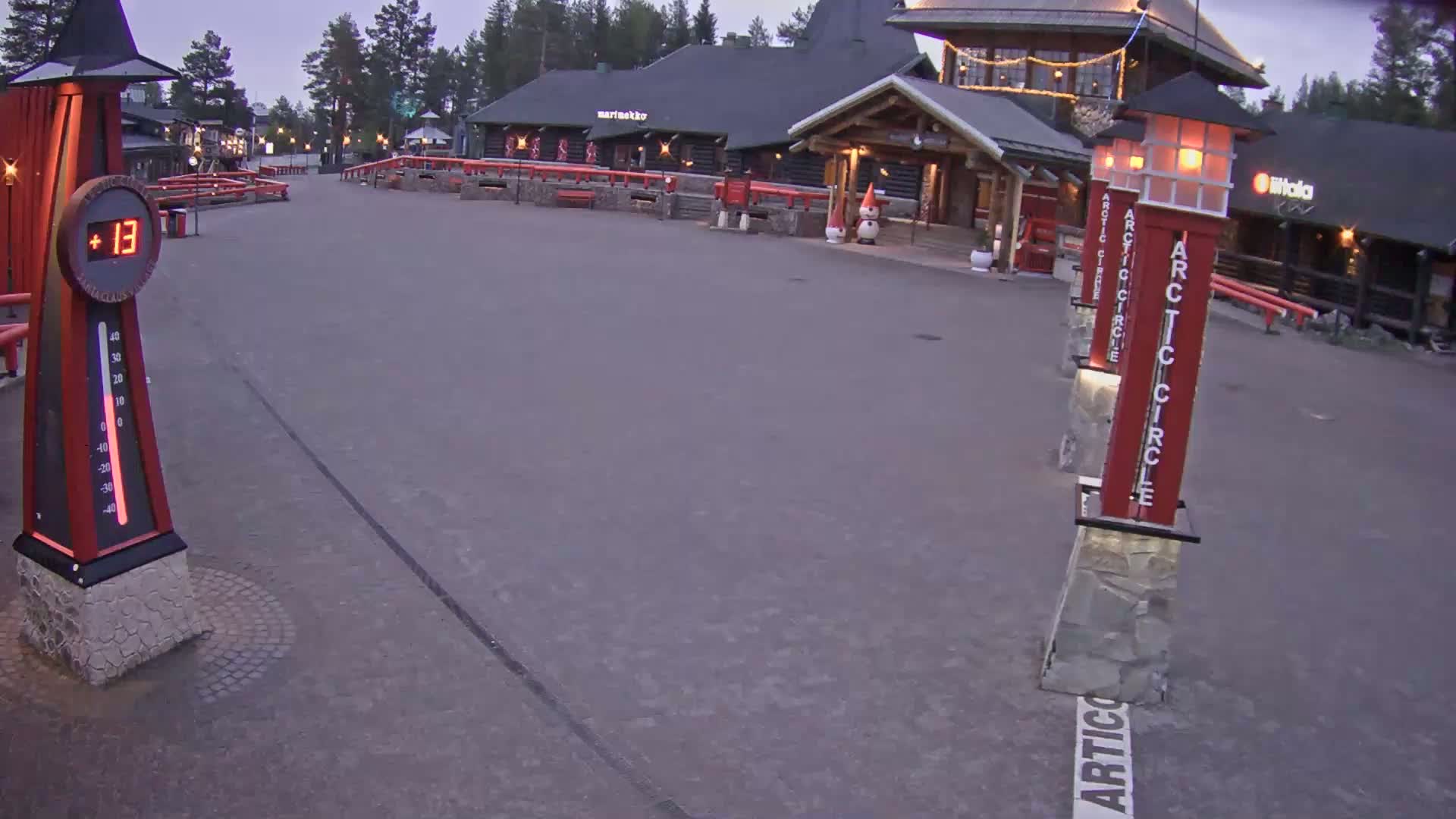 An empty paved area shows a row of lit "Arctic Circle" markers and a thermometer displaying 13 degrees, under a twilight sky.