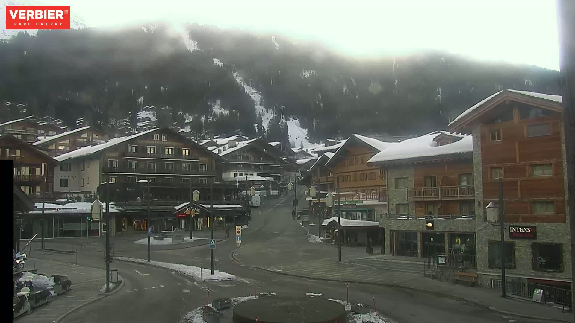 A snow-covered village nestled in a mountain valley on a cloudy day.