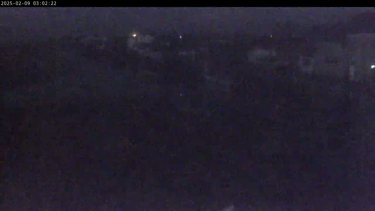 A dark, nighttime view of a sparsely lit landscape.