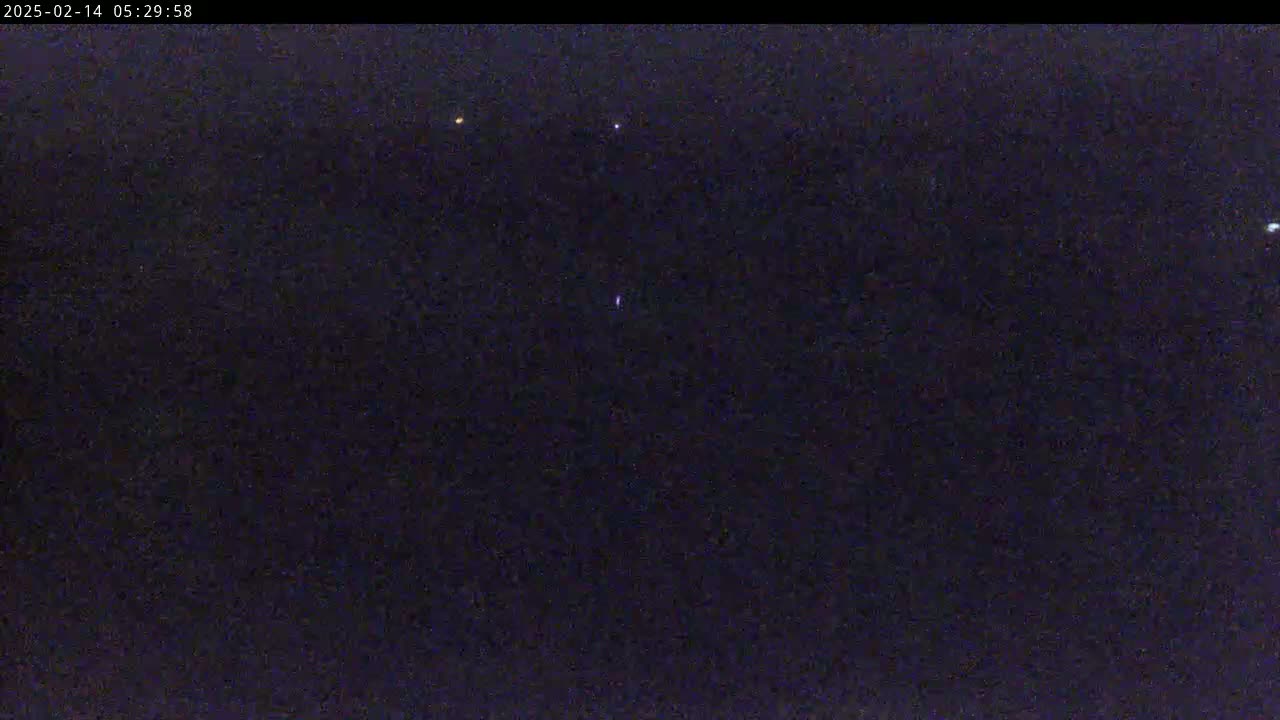 A dark night sky shows a few faint lights.