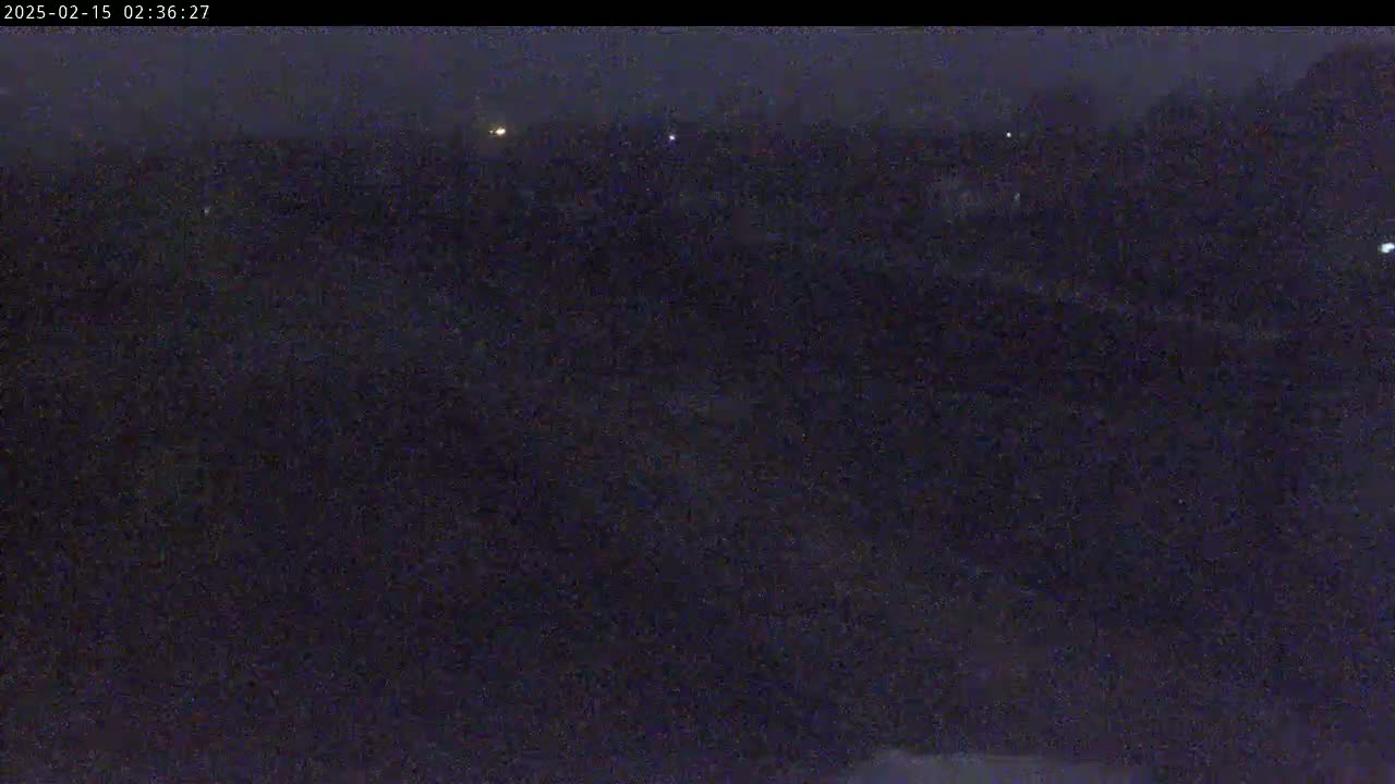 A dark, nighttime scene shows a flat, indistinct expanse of land under a dark, possibly overcast sky.