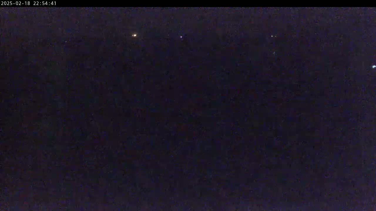 A dark night sky shows several distant lights.