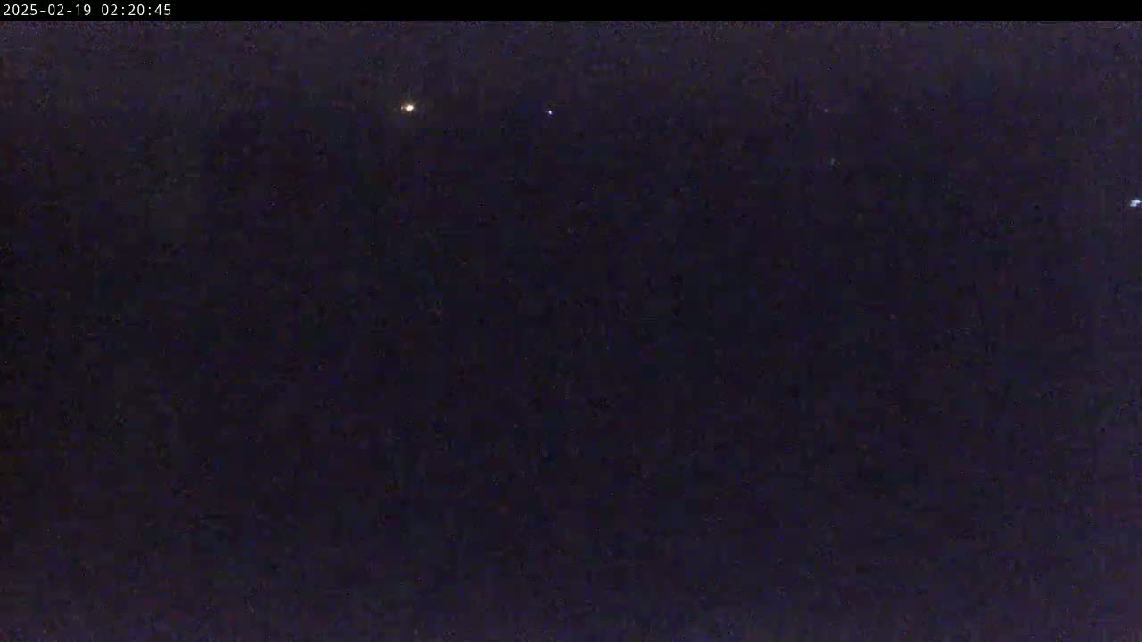 A nighttime image shows a dark sky with several faint lights visible.