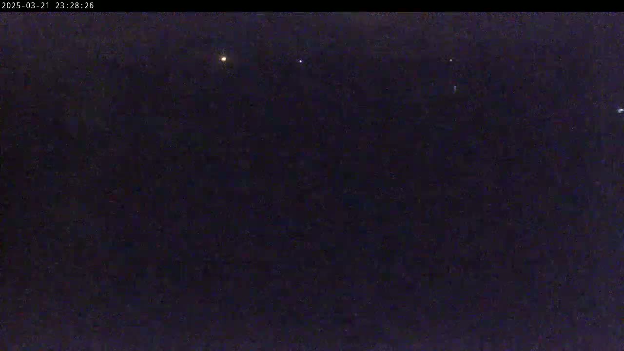 A dark night sky shows several faint lights.
