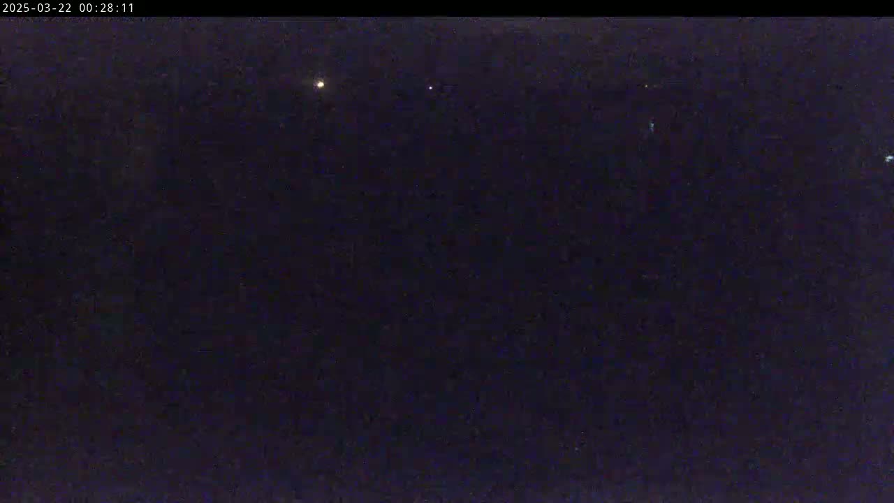 A dark night sky shows several faint lights.