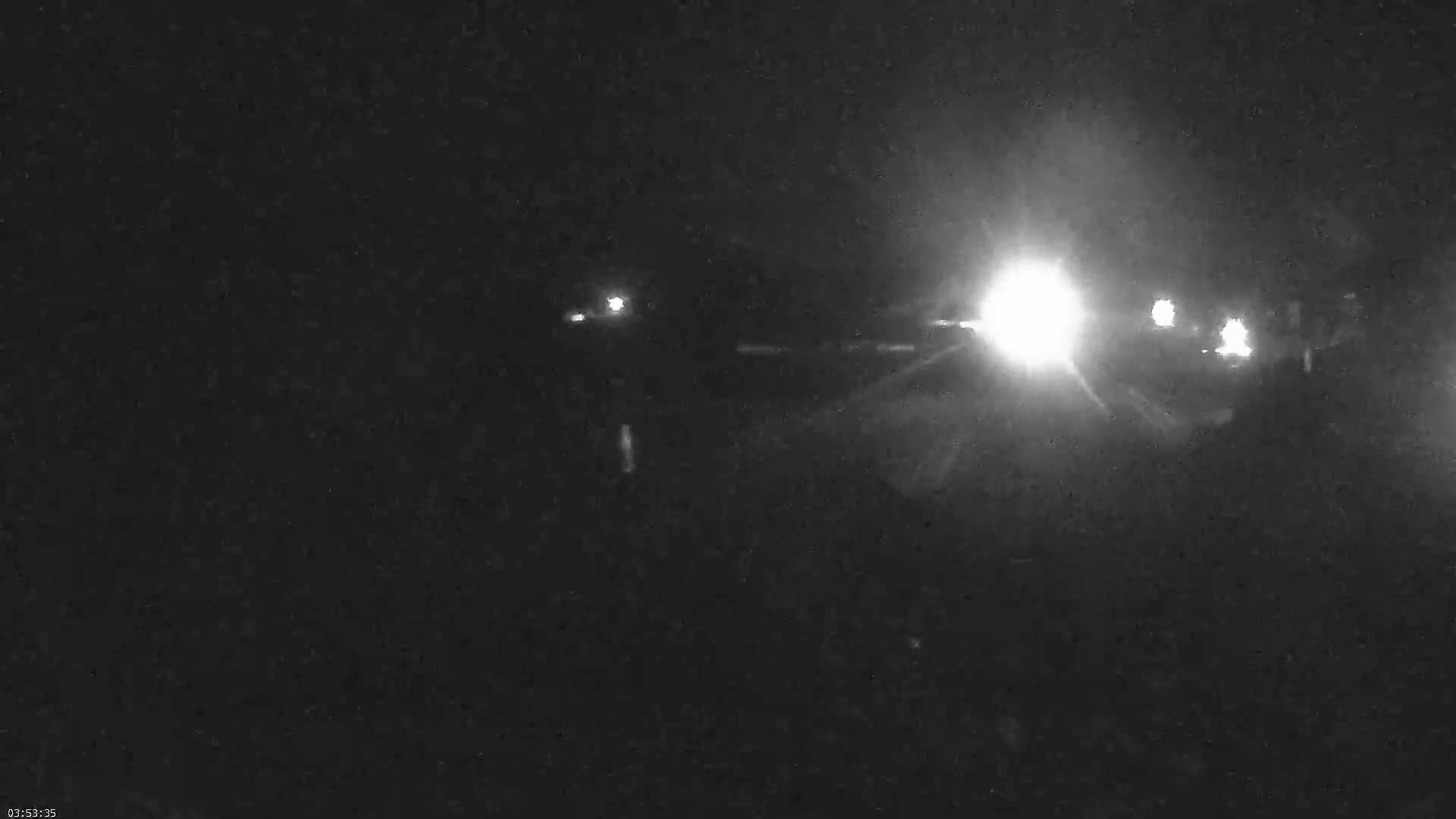 Headlights from vehicles are visible at night.