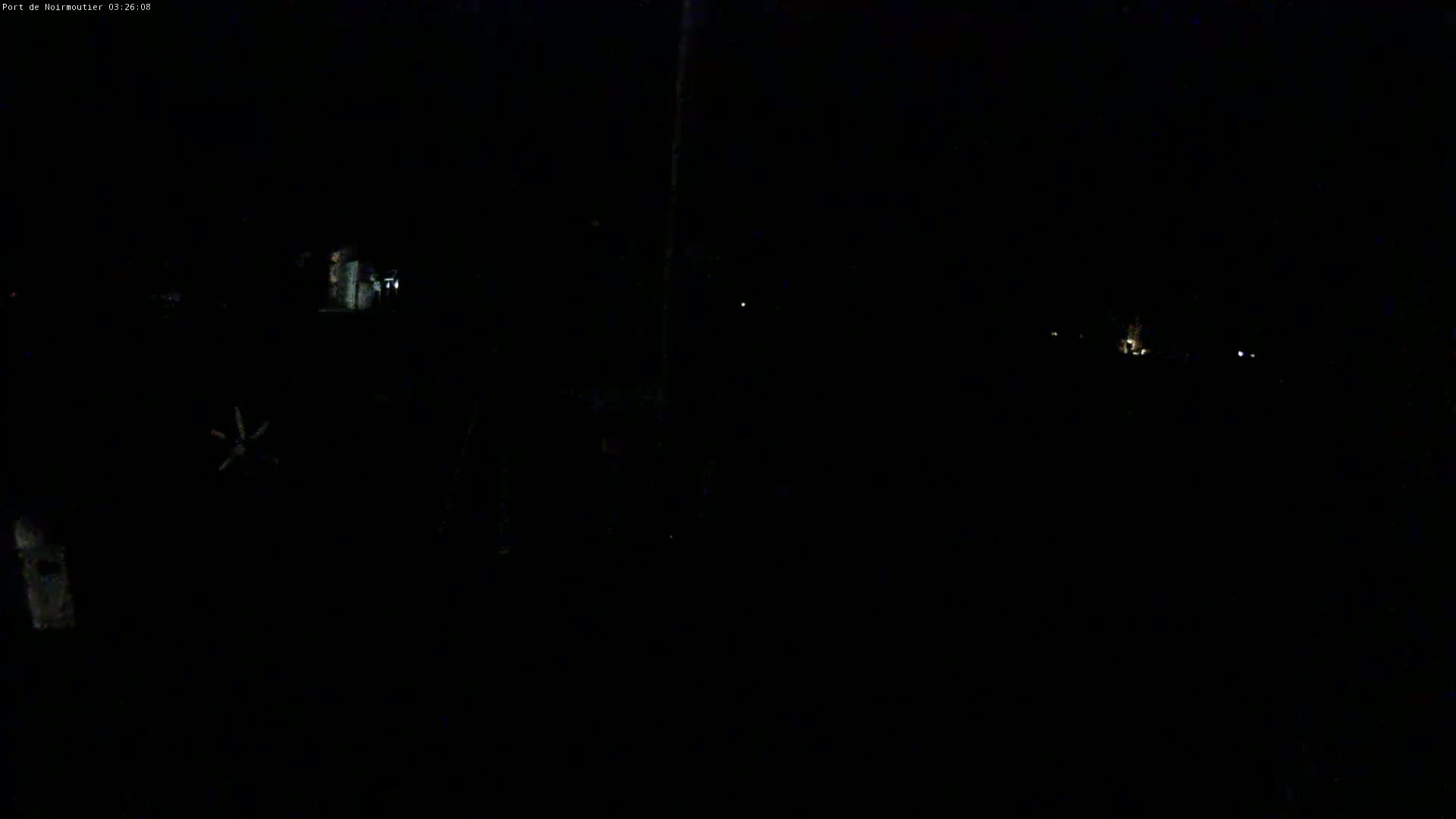 A dark, nighttime scene shows a few faint lights in the distance.