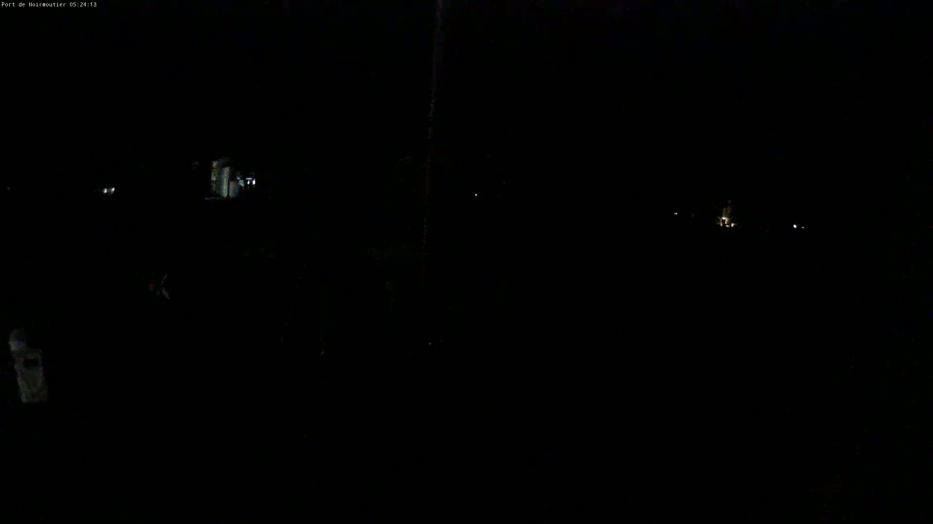 A very dark nighttime scene shows a few faint lights in the distance.