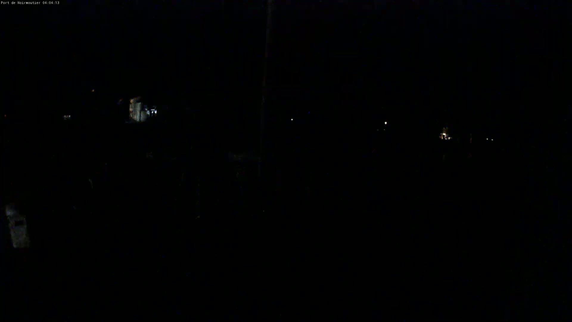 A very dark nighttime scene shows a few faint lights in the distance.