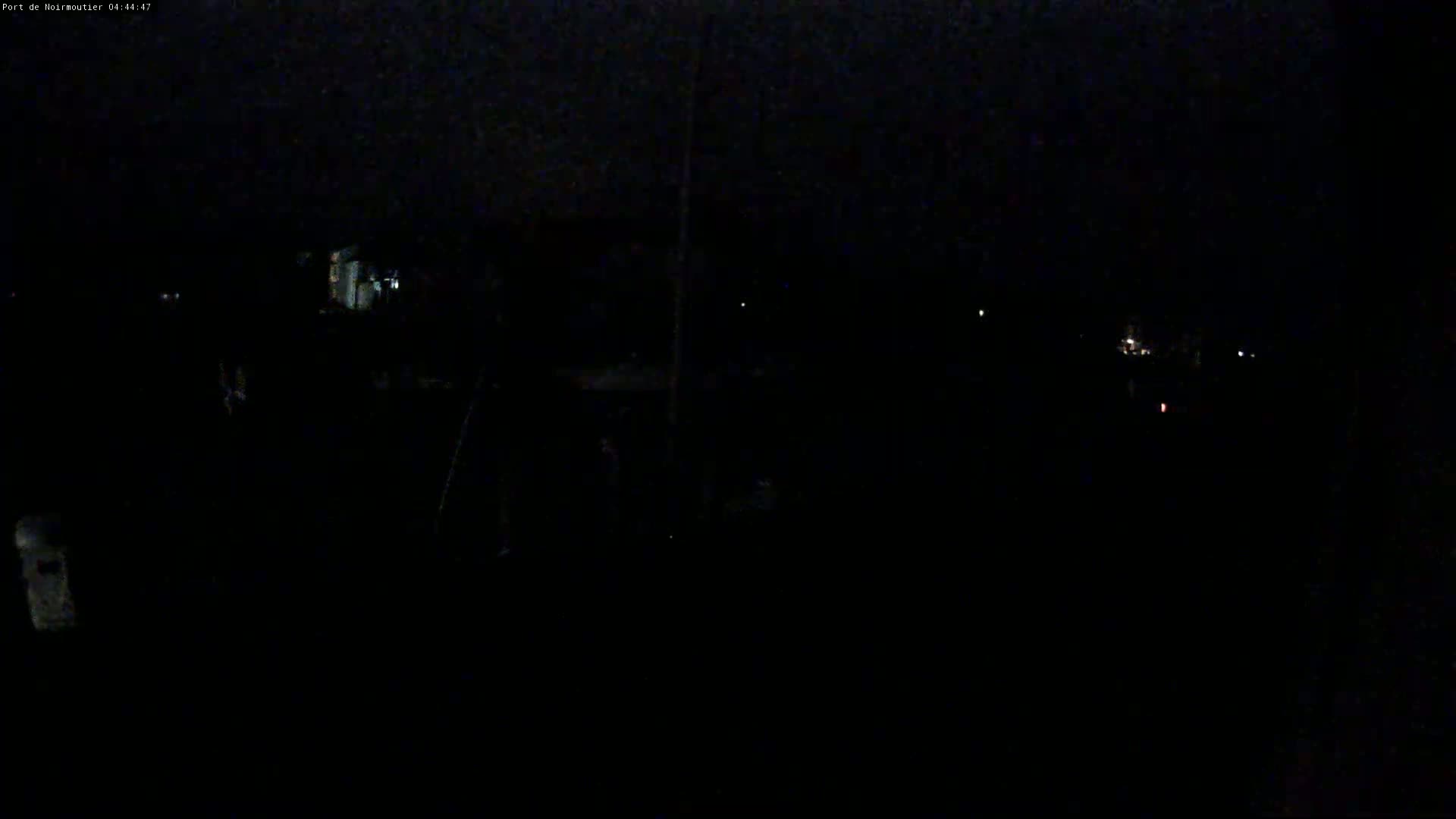 A dark, nighttime scene shows a few distant lights and a mostly obscured foreground.