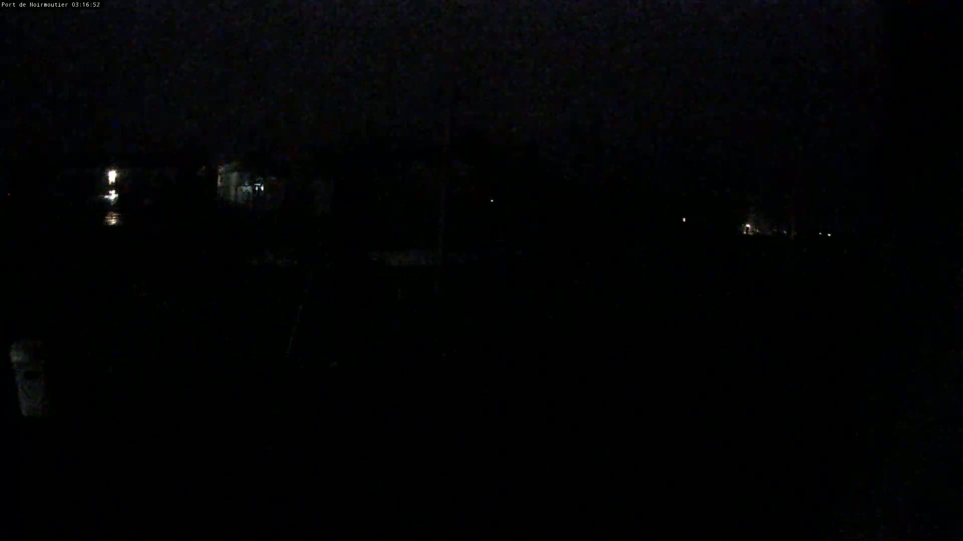 A dark, nighttime scene shows a few faint lights in the distance.