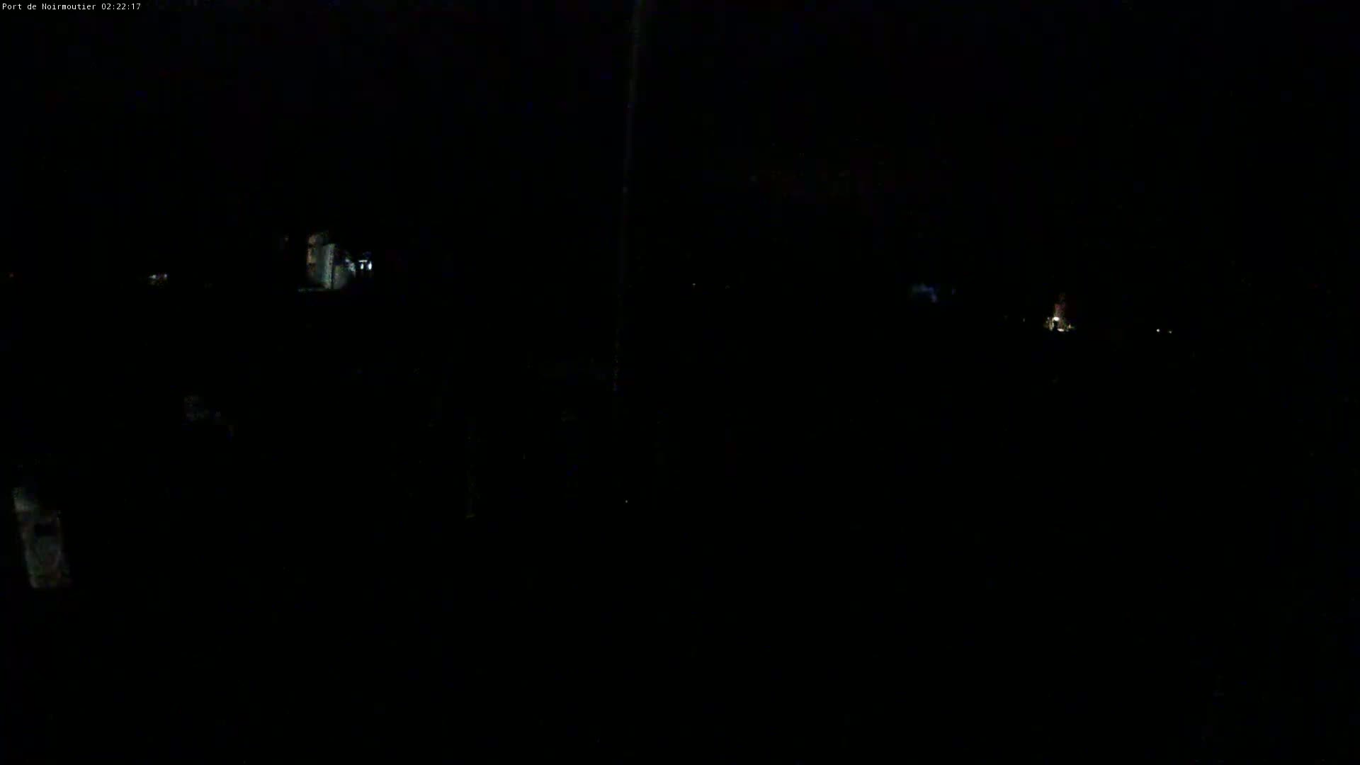 A dark, nighttime scene shows faintly lit buildings in the distance.