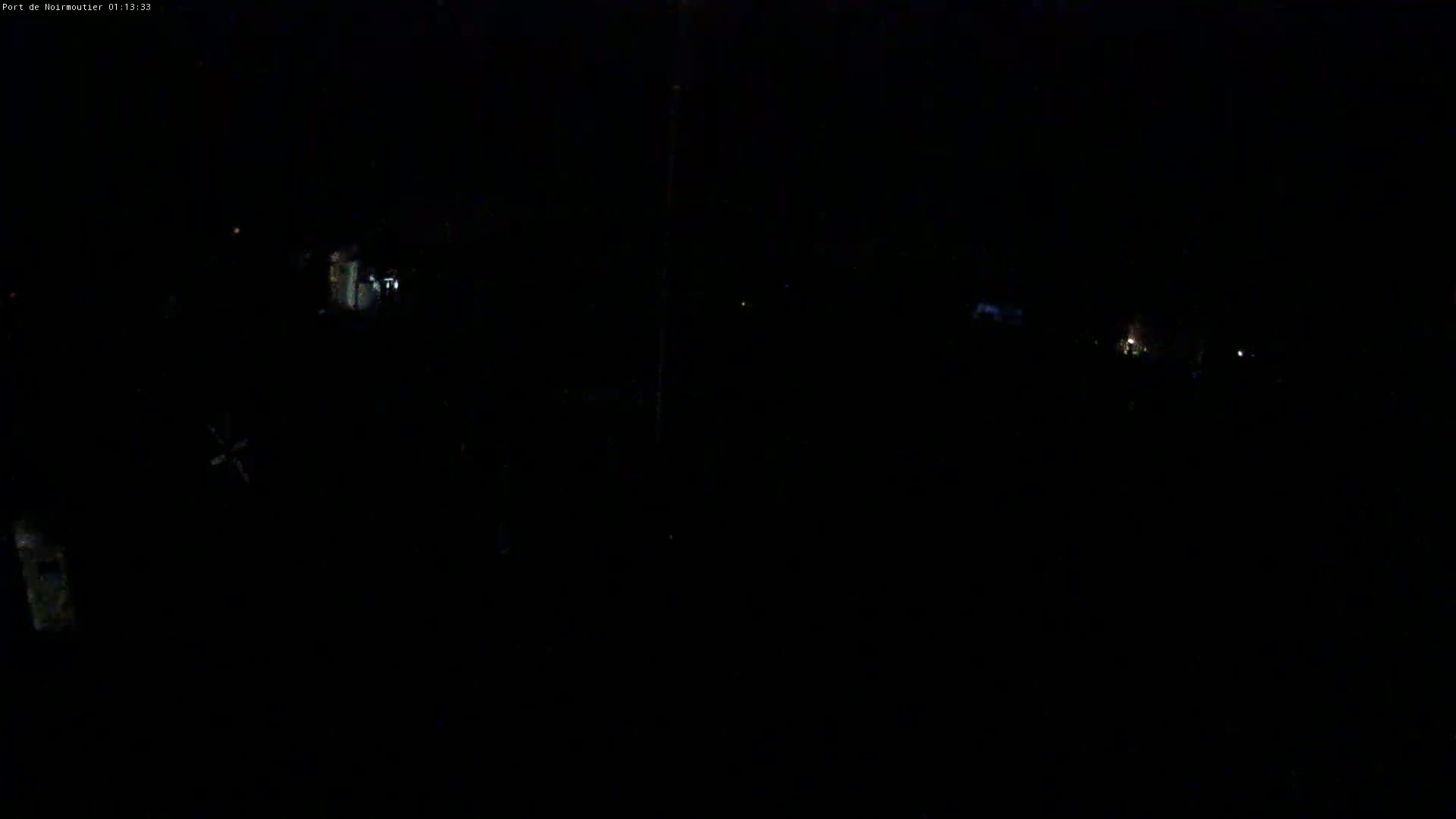 A very dark nighttime scene shows a few faint lights in the distance.