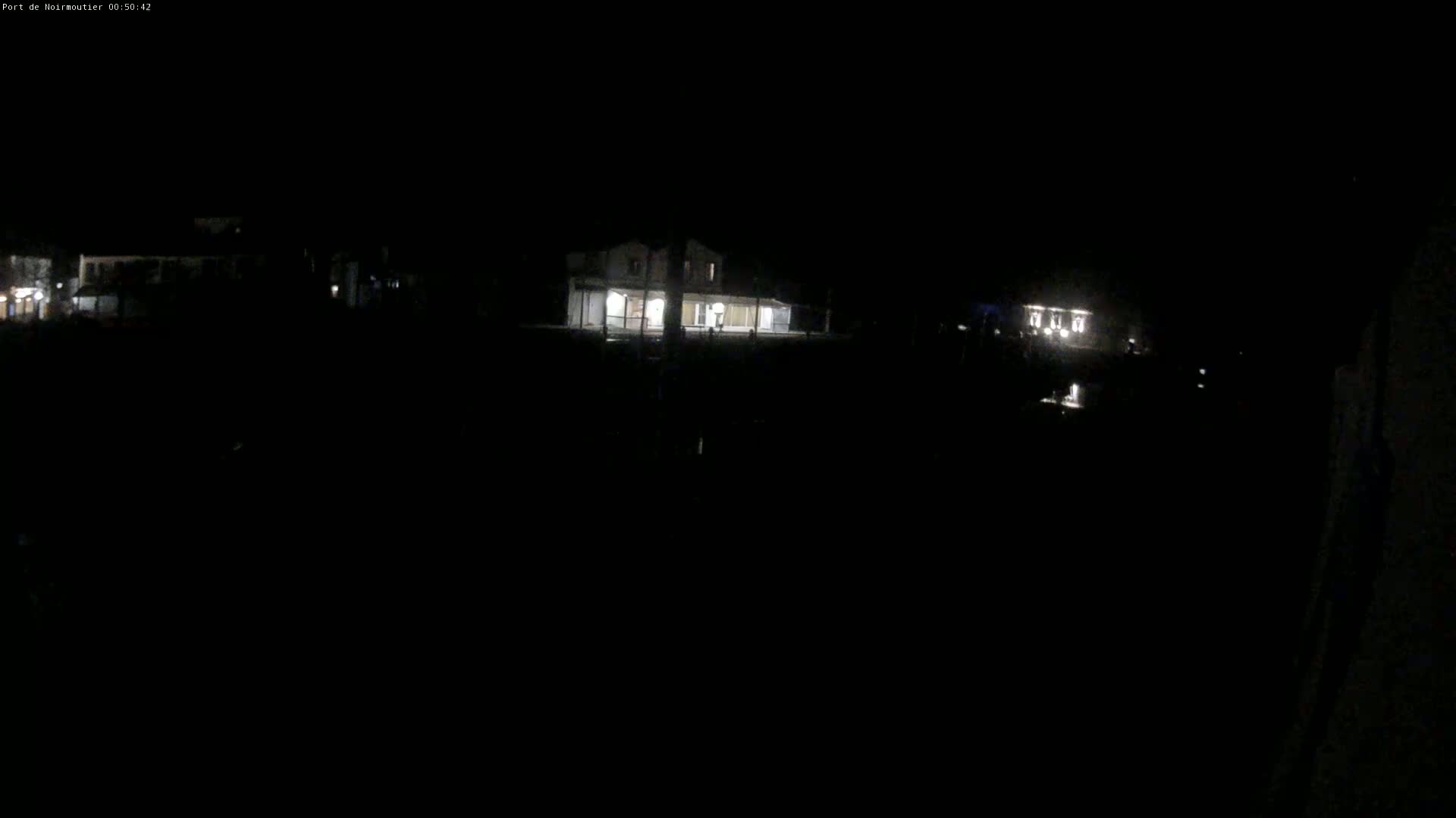 A dimly lit building is visible at night, with other faint lights in the distance.
