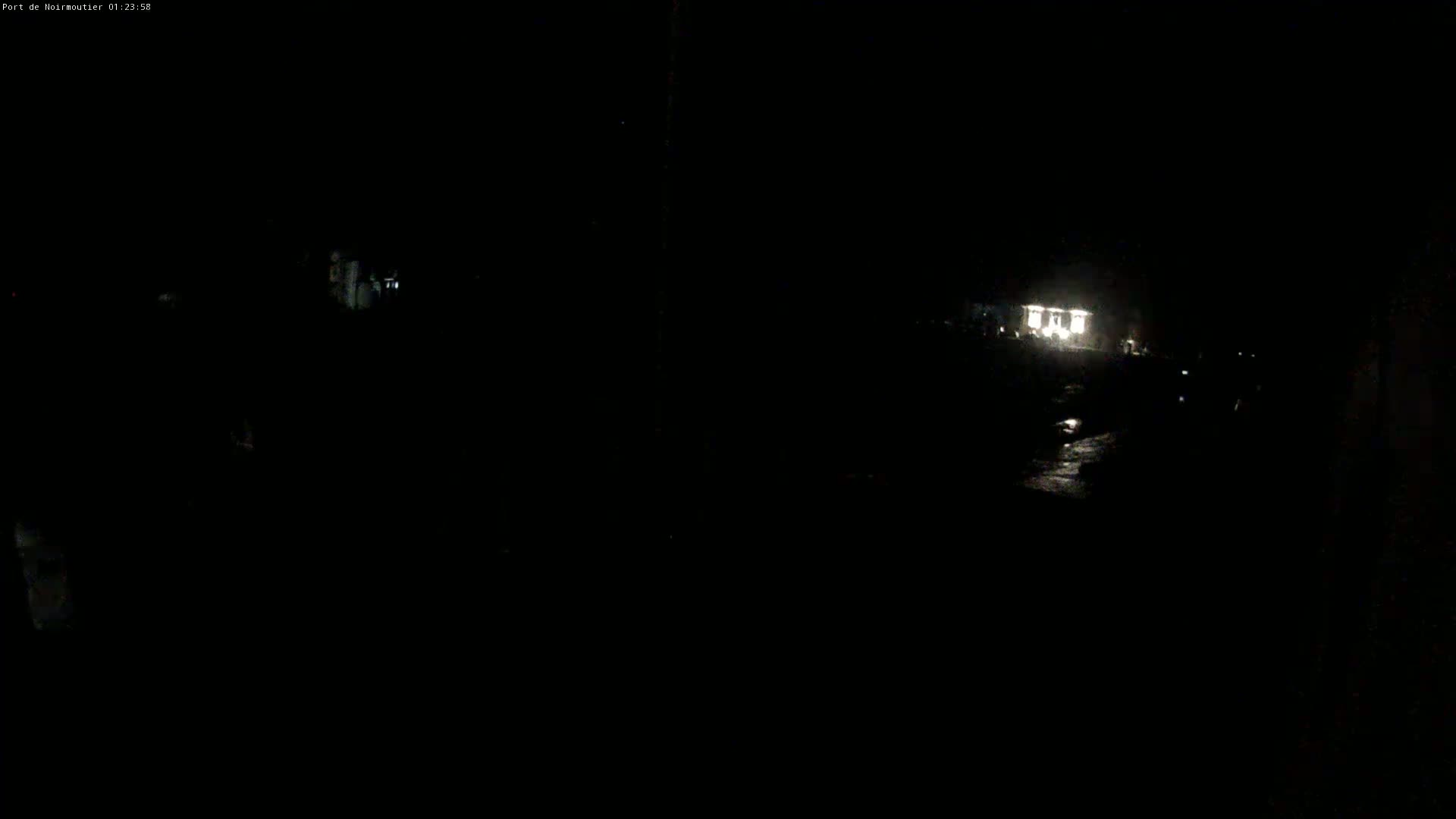 A dimly lit building is visible in the distance at night.