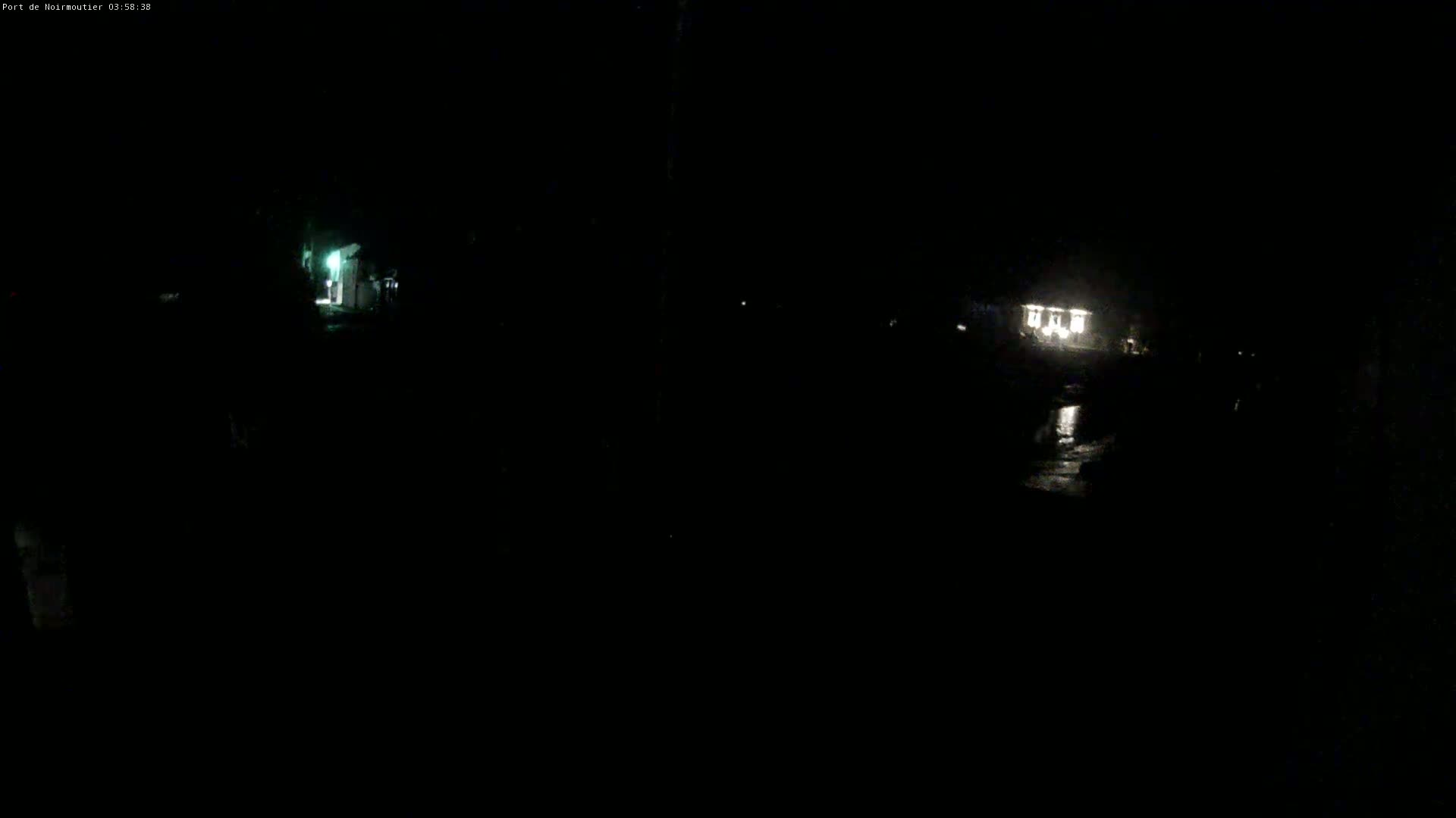 At night, dimly lit buildings are visible across a dark, possibly wet, expanse.