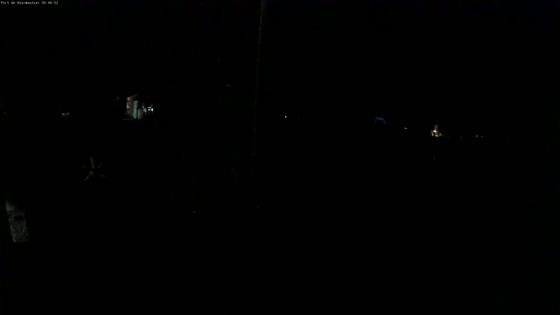 A dark, nighttime scene shows faintly lit buildings and a few distant lights.