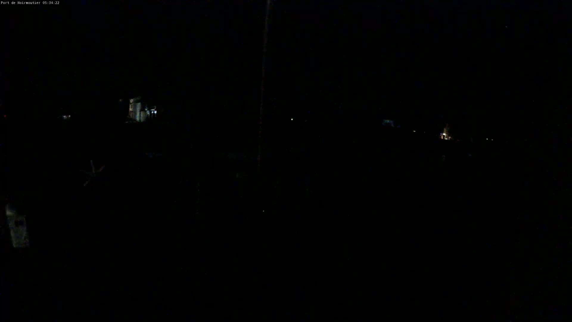 A very dark, nighttime scene shows a few faint lights in the distance.