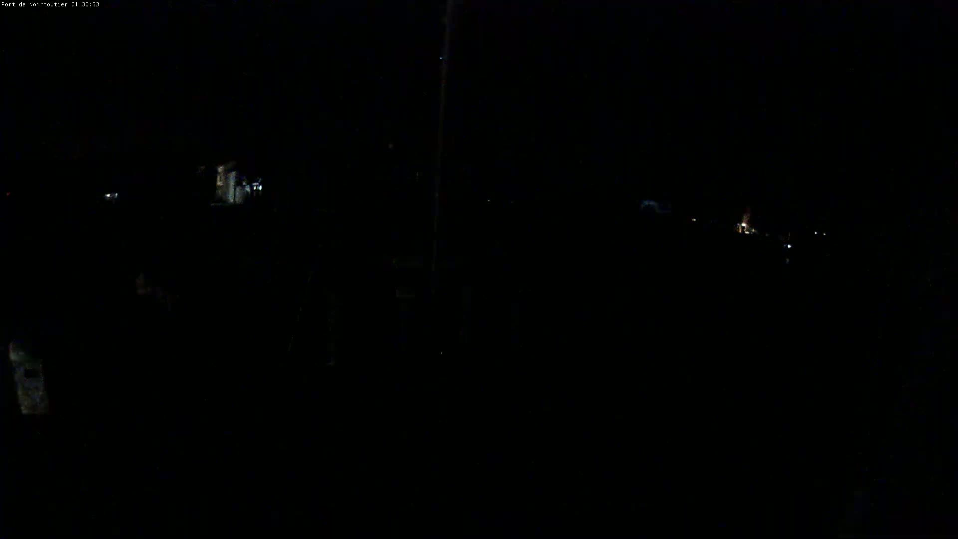 A very dark, nighttime scene shows a few faint lights in the distance.