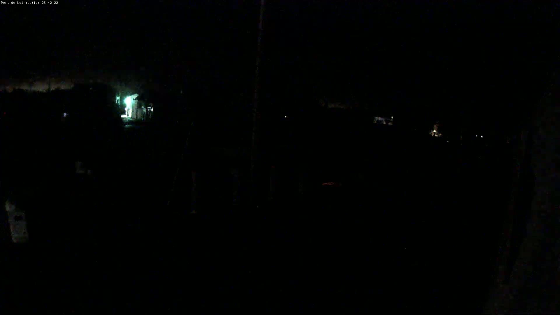 A dark, nighttime scene shows dimly lit buildings and faint lights in the distance.