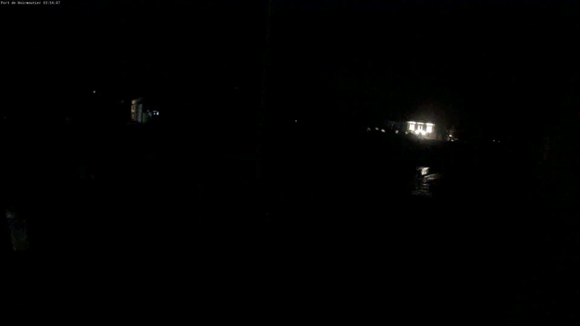 A dimly lit structure is visible in the distance at night.