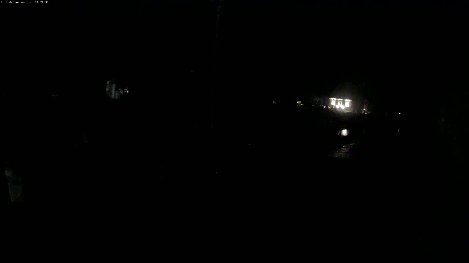 A dimly lit building is visible in the distance at night.