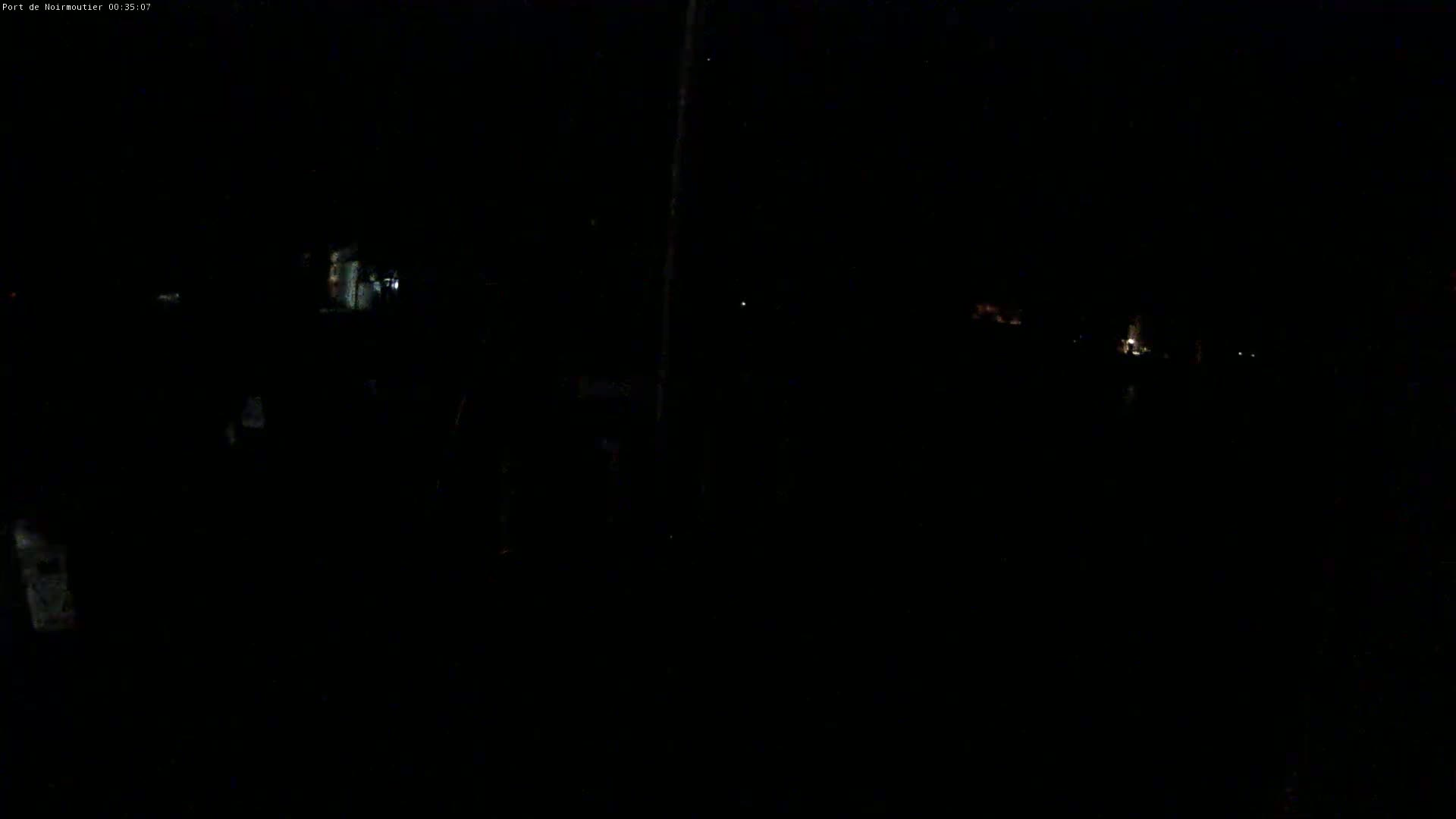 A very dark nighttime scene shows faint lights in the distance.