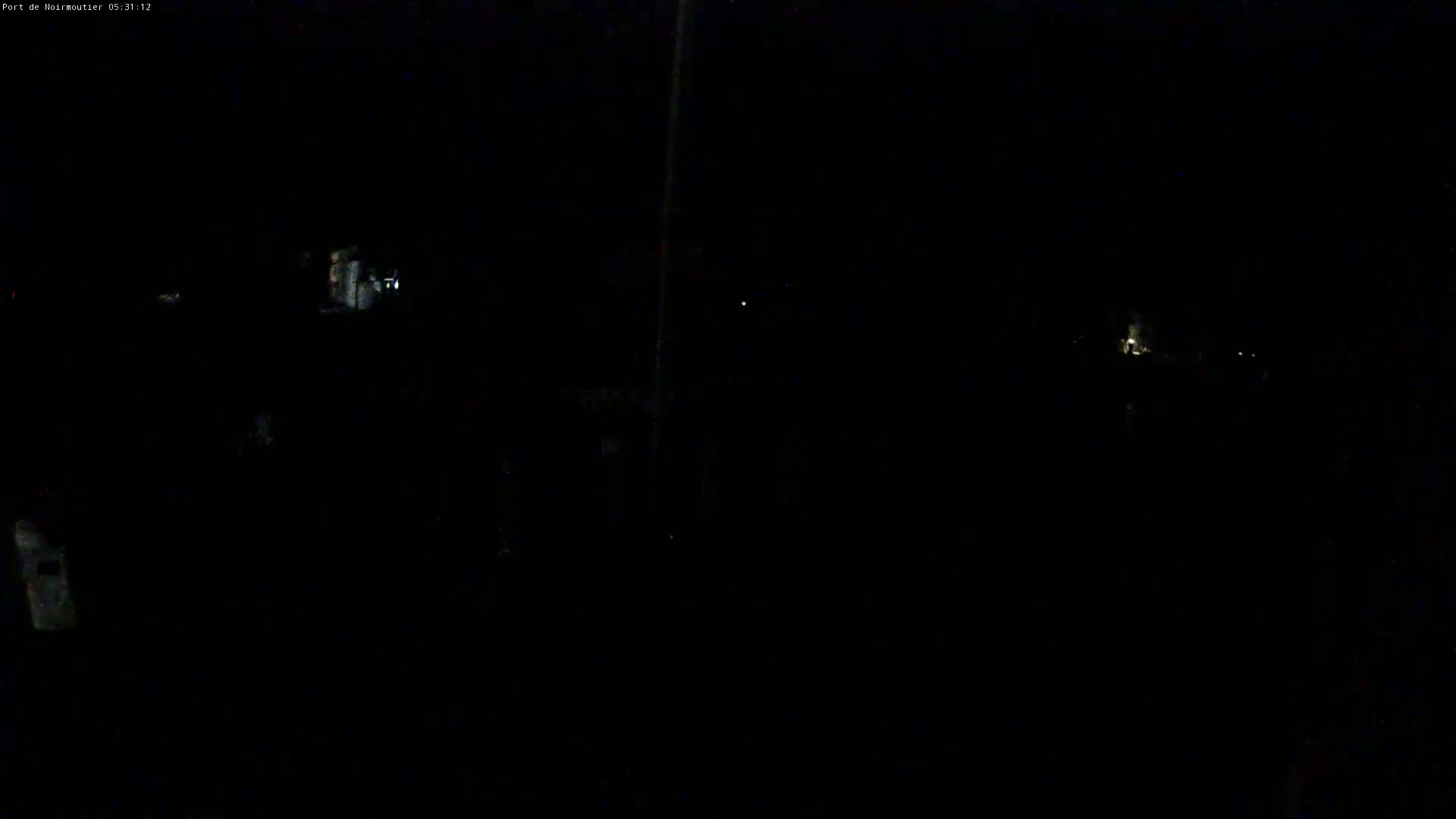 A very dark nighttime scene shows a few faint lights in the distance.