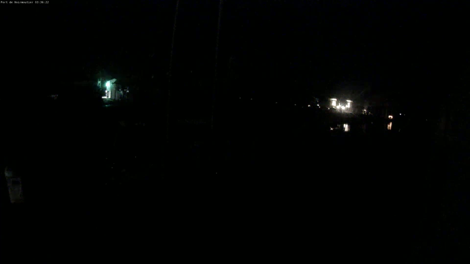 A dark, nighttime scene shows dimly lit buildings and faint lights in the distance.