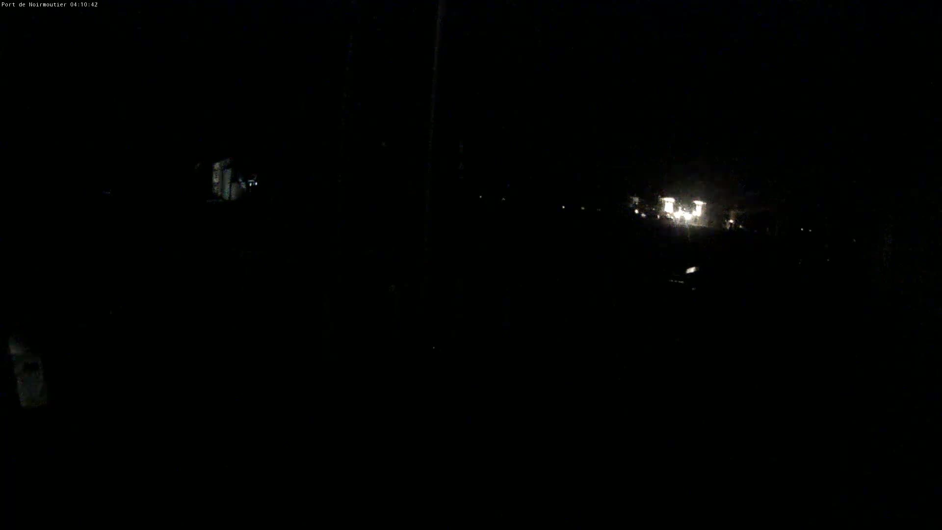 A dark nighttime scene shows faint lights in the distance.