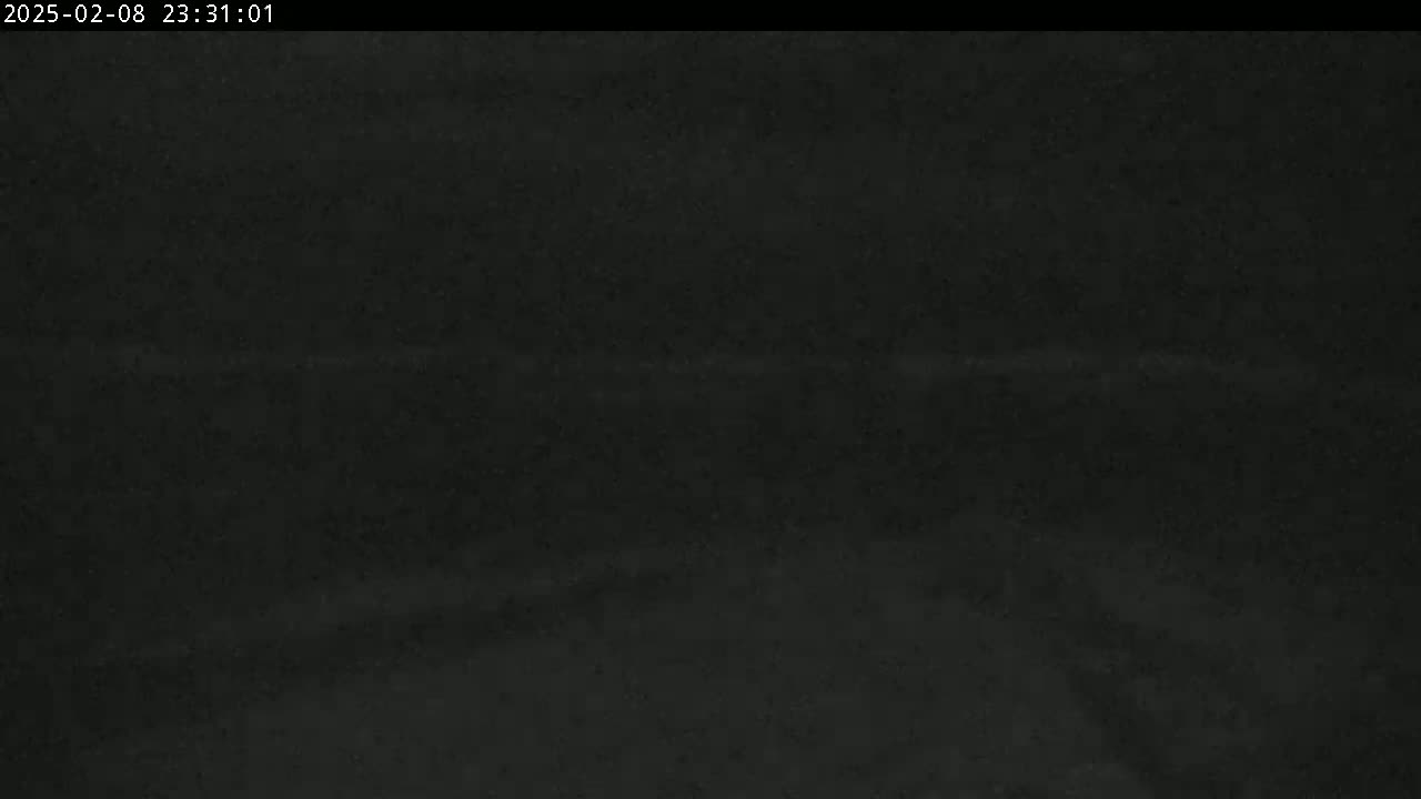 A dark, possibly nighttime image shows a mostly featureless black expanse with a faint, horizontal light streak near the center.
