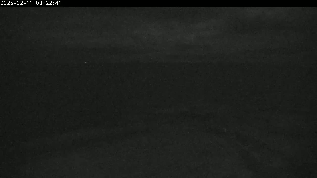 A dark, nighttime outdoor scene with a mostly overcast sky.