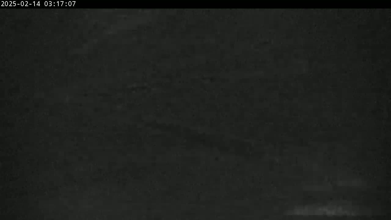 A very dark, possibly nighttime image shows a blurry, indistinct view of a dark surface.