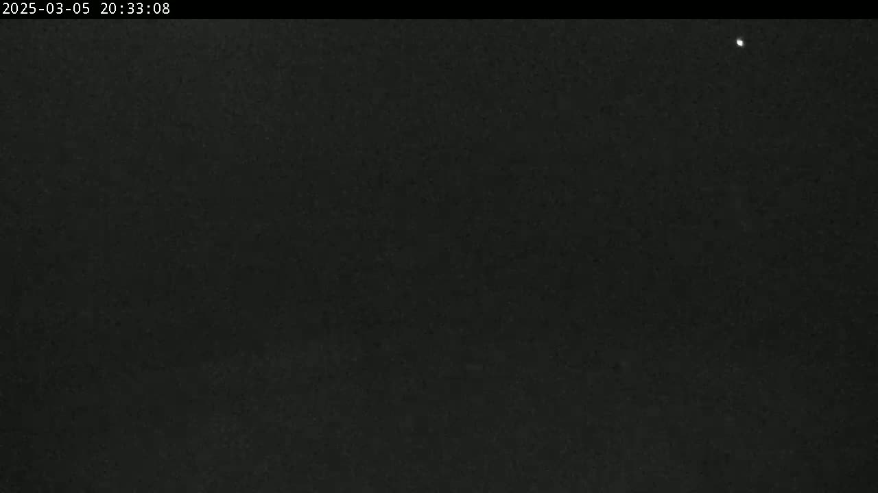A dark, nighttime scene shows a mostly clear sky with one visible star.